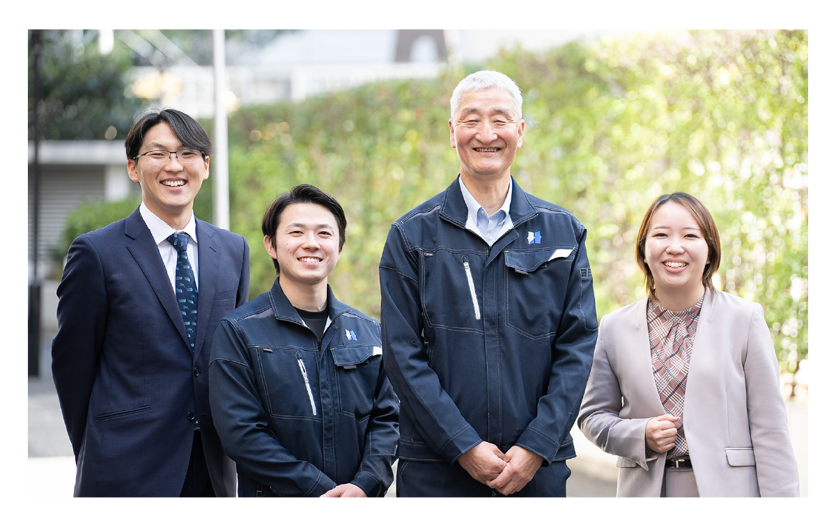 先輩社員と3人の若手社員が笑顔で映っている職場の風景